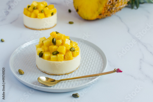 mini cheesecakes with pineapple and pistachios on a light background