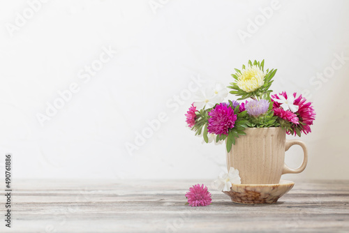 Wallpaper Mural beautiful flowers in cup on wooden table on background white wall Torontodigital.ca