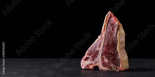 Raw beef steak, dry aged T bone on black background Fototapet