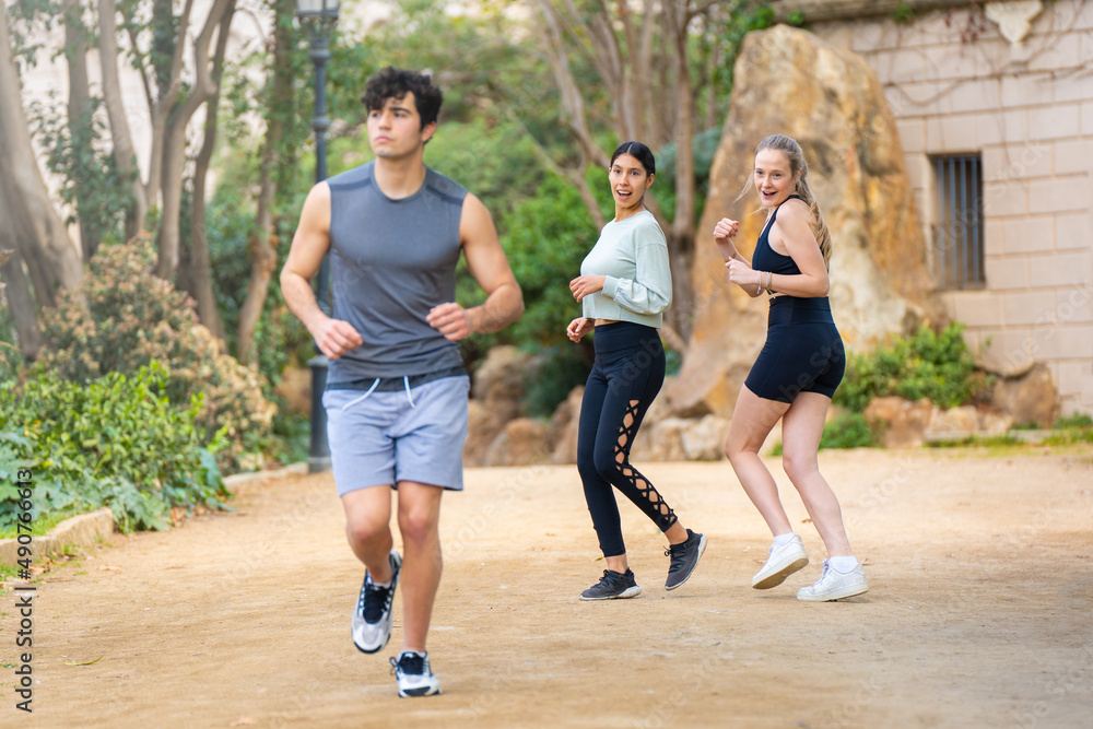 Two young women looking at an attractive man while playing sports