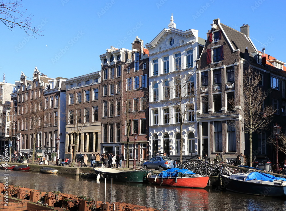 Amsterdam Kloveniersburgwal Canal View with Historic House Facades, Boats and People, Netherlands