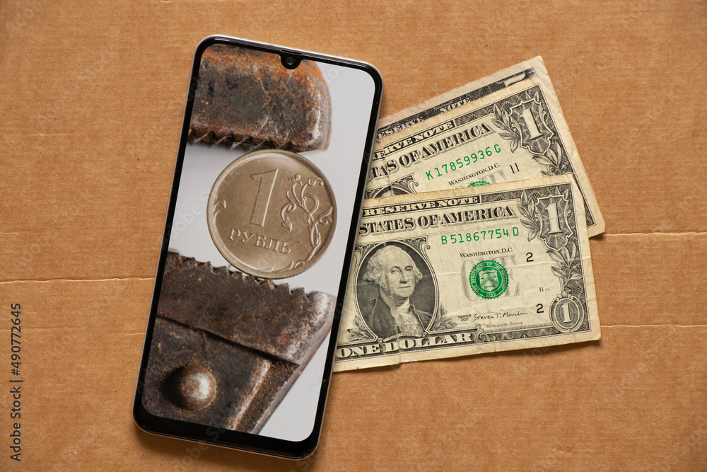 The gas key holds the Russian ruble as a background in the phone and dollars lie nearby, the collapse of the ruble, sanctions against Russia, the economic crisis in Russia and losses The gas key holds the Russian ruble as a background in the phone and dollars lie nearby, the collapse of the ruble, sanctions against Russia, the economic crisis in Russia and losses