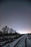 snowy landscape  forest in the night . Night landscape. Nightsky and clouds . Stars in the sky . Lights of the city . 