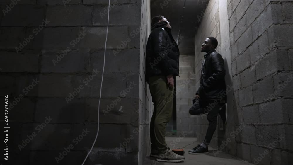 Caucasian guy and black guy are standing in a basement Caucasian guy and black guy are standing in a basement