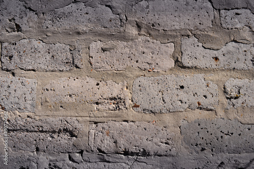 Background of a gray wall laid on a mortar of old bricks