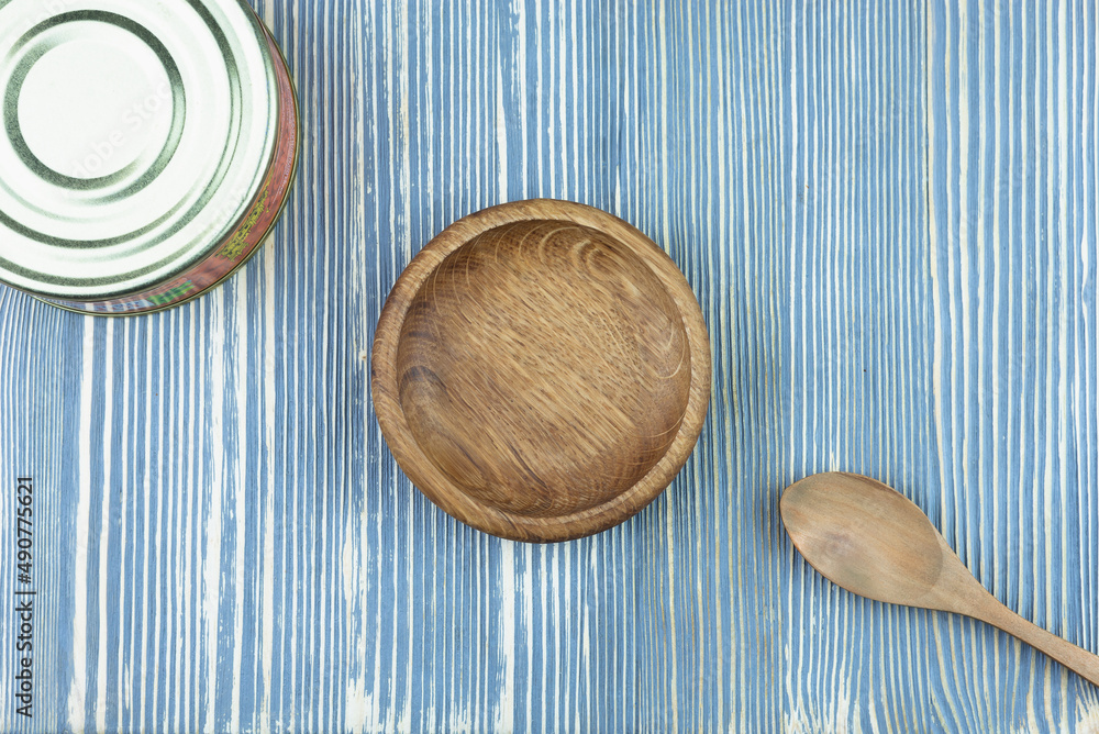 Canned food and wooden utensils on a wooden table. Canned food and wooden utensils on a wooden table.