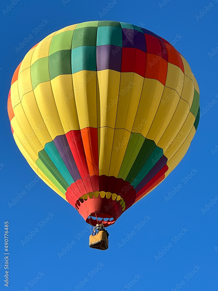Obraz premium Hot Air Ballon in Many Colors Glides over Desert