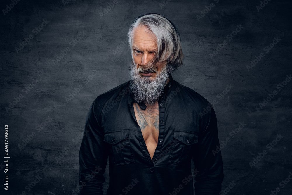 Fototapeta premium Aged bodybuilder dressed in stylish black shirt staring at camera
