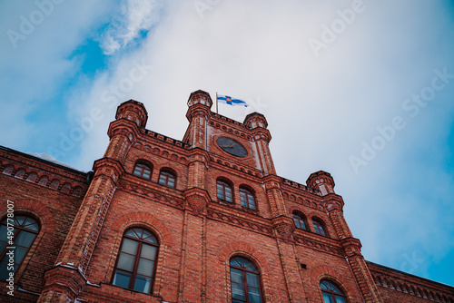 Vaasa court of appeal building with a Finnish flag on top during a cloudy day
