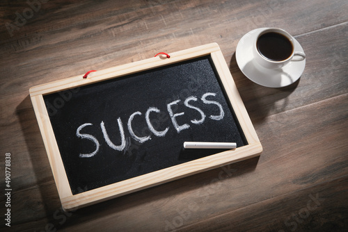Success text on blackboard with a coffee.