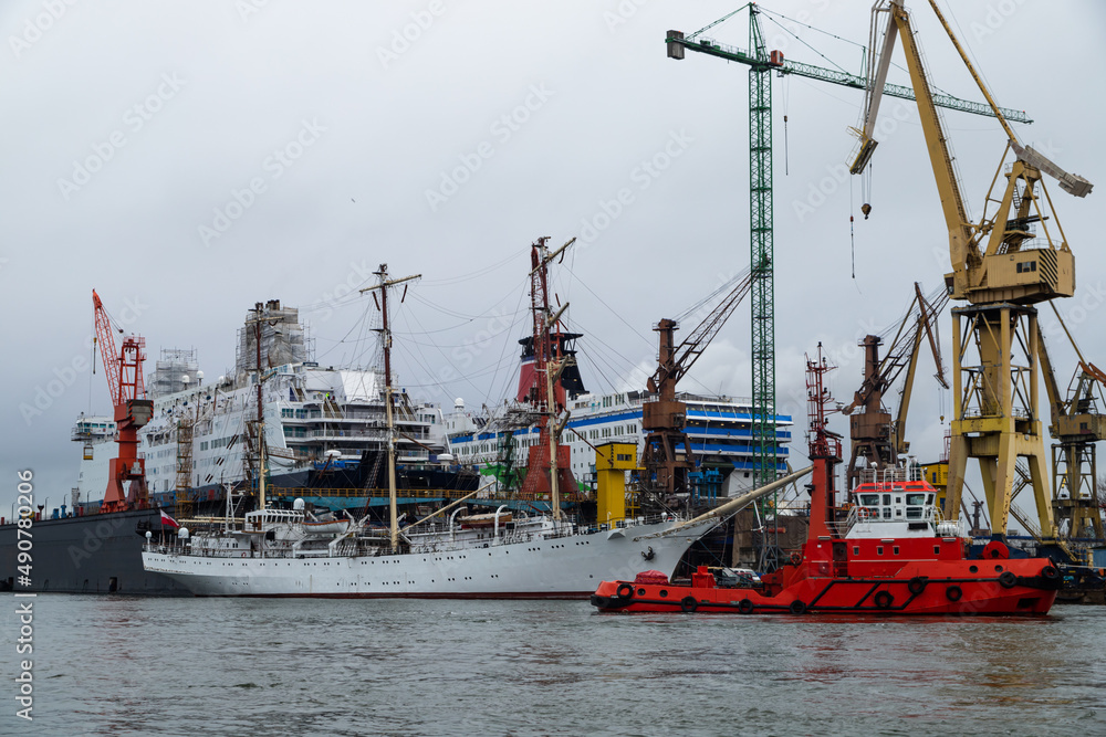 A three-masted sailing ship under repair in a shipyard 