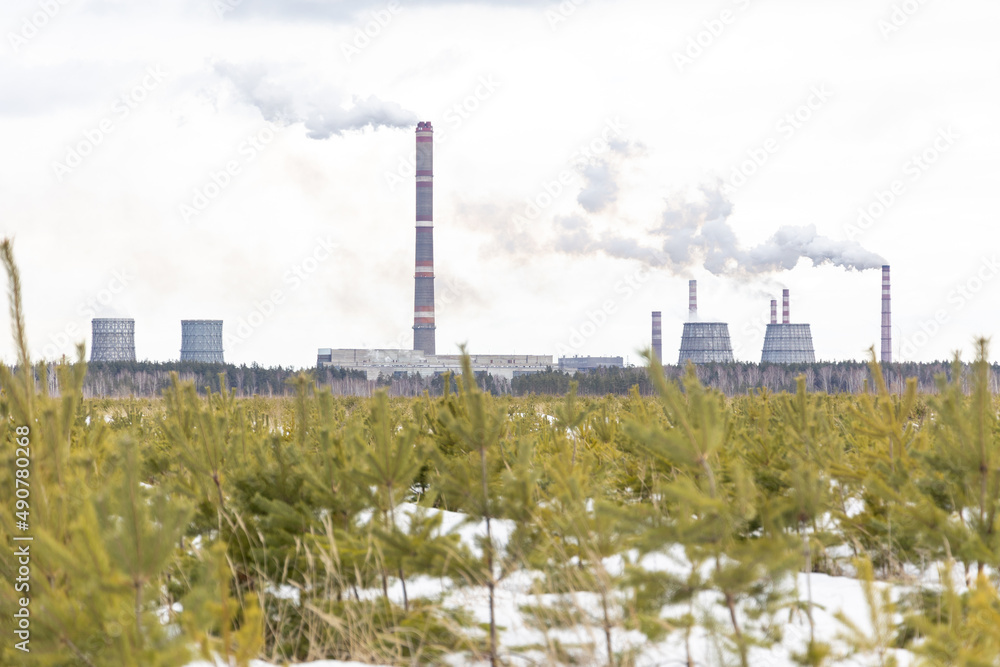 Obraz premium Smoking city chimneys. Smoking factory against the background of small Christmas trees