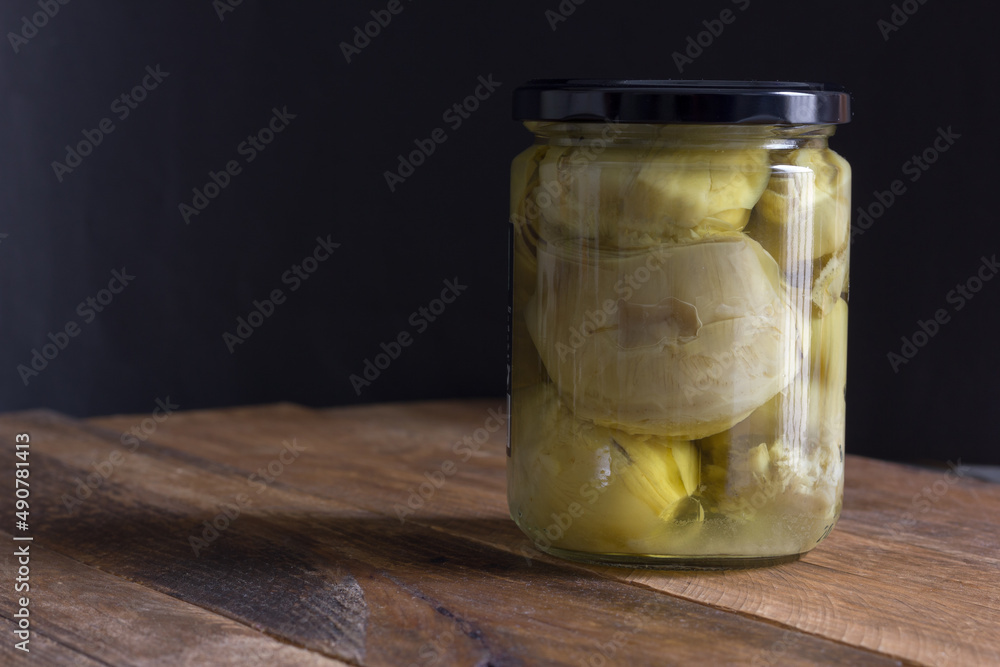 Glass jar with artichokes in rustic style. Healthy and vegetarian food, vegan. Copy space. Glass jar with artichokes in rustic style. Healthy and vegetarian food, vegan. Copy space.