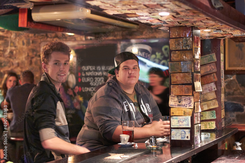 Having a pint with his pal. Two friends drinking at the local bar.