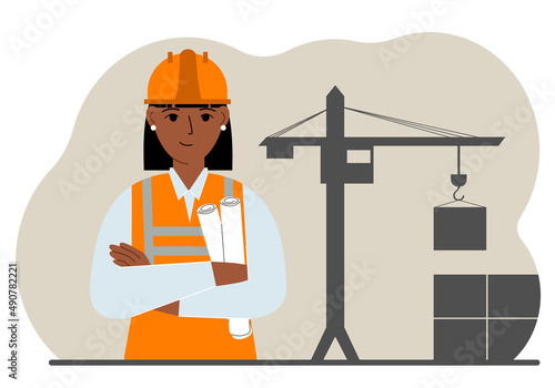 Happy engineer near the construction crane. Builder holding blueprints near construction machinery.