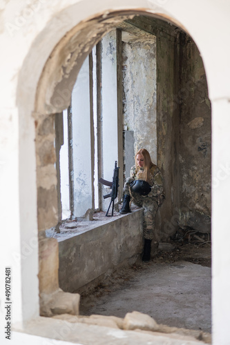 Caucasian military woman in a destroyed building.  © Михаил Решетников
