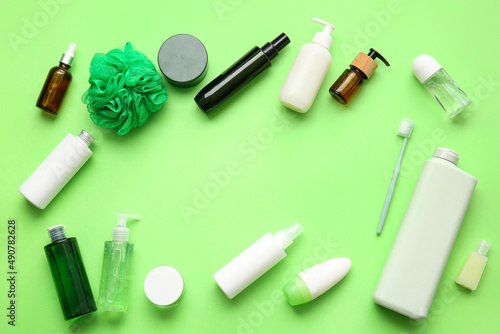 Frame made of cosmetic products, toothbrush and bath sponge on green background