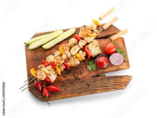 Wooden board of grilled chicken skewers with vegetables isolated on white background