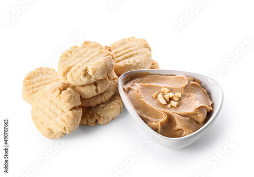 Tasty peanut cookies and bowl with butter on white background