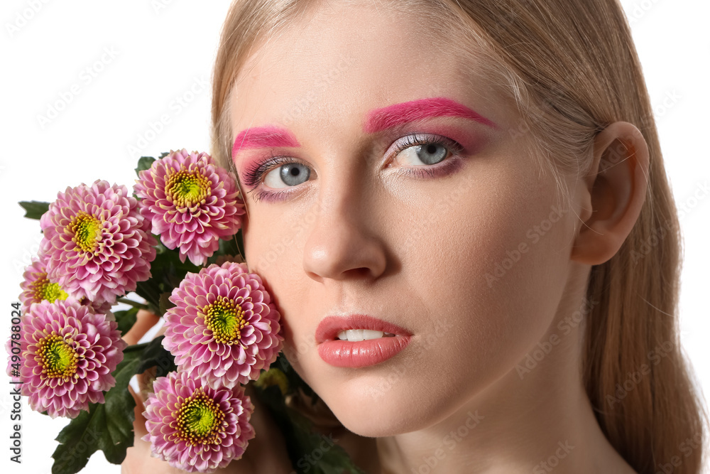 Beautiful woman with creative makeup holding beautiful flowers on white background