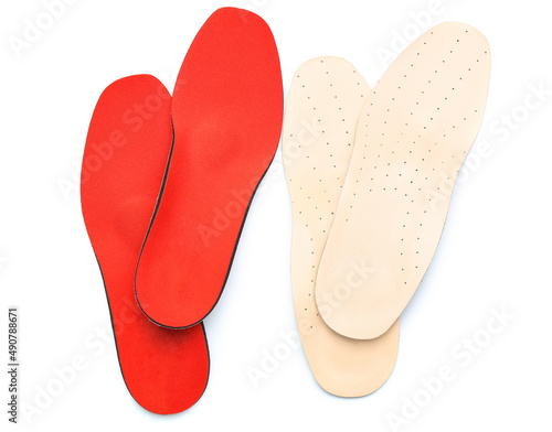 Two pairs of orthopedic insoles on white background