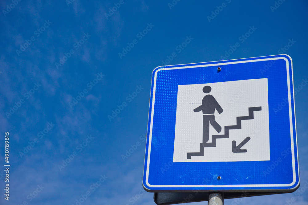 underpass sign for pedestrians and blue sky