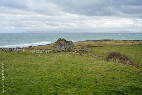 ruins of old church and graveyard Kilcummin Co. Mayo, Ireland with Atlantic Ocean on the background