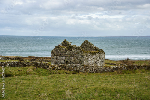 ruins of old church and graveyard Kilcummin Co. Mayo, Ireland with Atlantic Ocean on the background