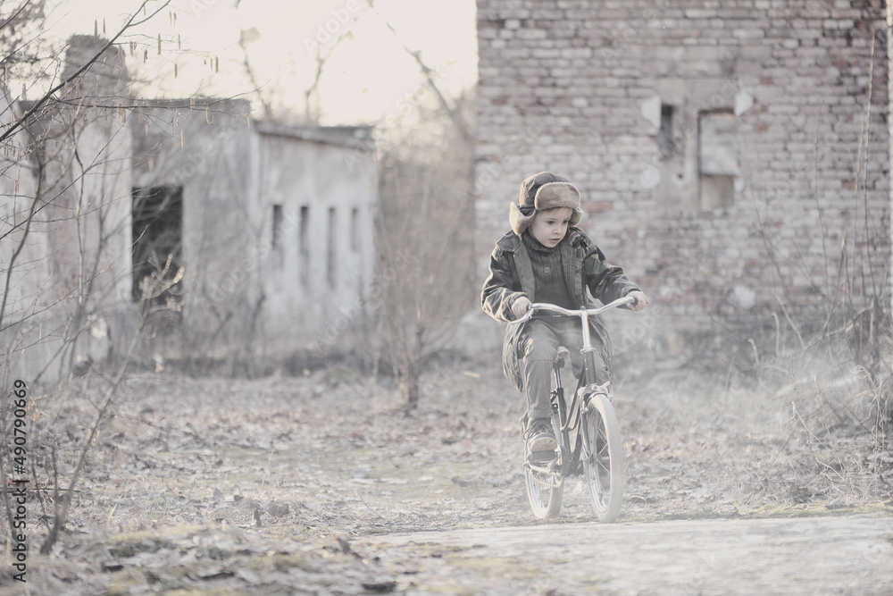 Child and war. Poor, homeless child in the ruins of a destroyed house ...