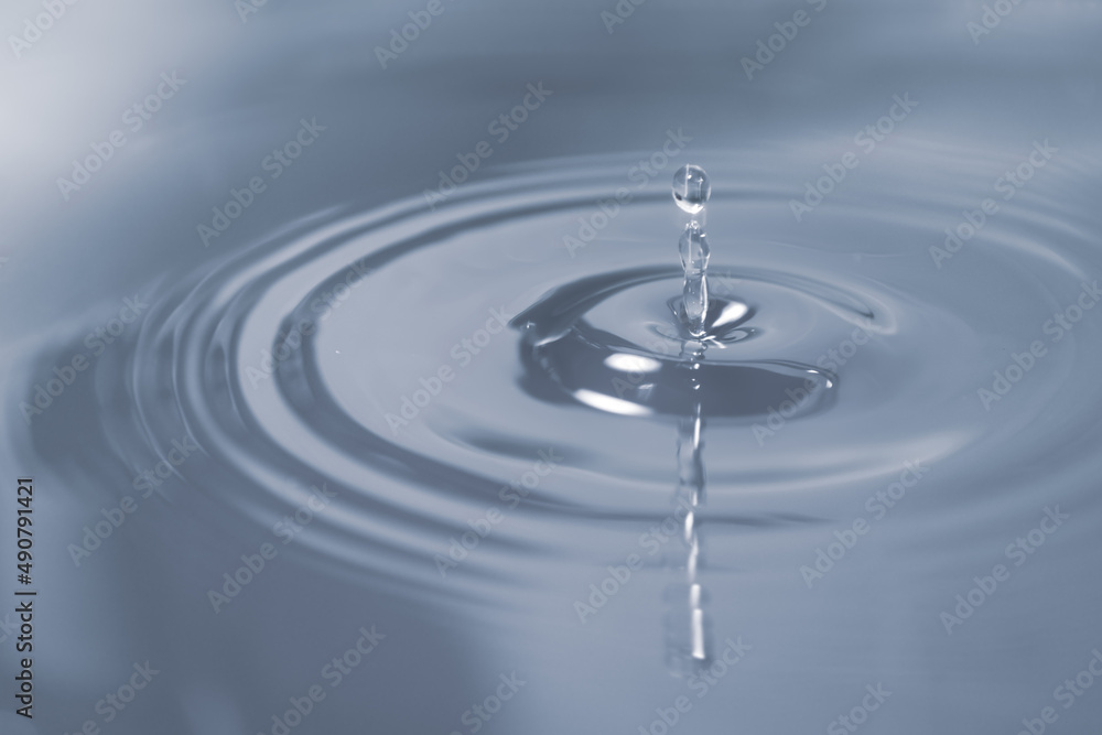 Circles on the water from falling drops. Photo in gray-blue shades. Circles on the water from falling drops. Photo in gray-blue shades.