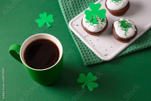 Coffee and three cupcakes for celebration St Patricks Day on green background. Close up. photo