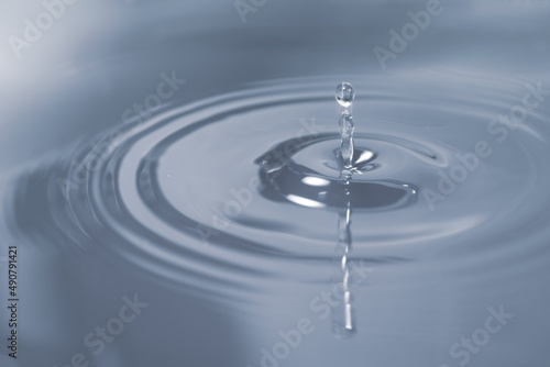 Circles on the water from falling drops. Photo in gray-blue shades.