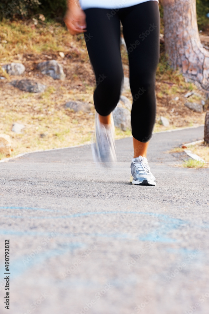 Woman jogging. Low section of woman jogging on pathway. Woman jogging. Low section of woman jogging on pathway.