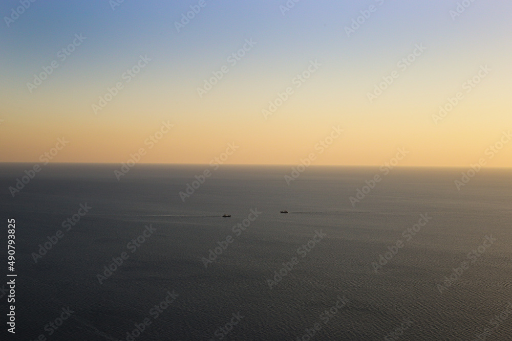 Two ships sailing towards each other in the middle of the sea against the backdrop of a picturesque horizon with a gradient sky at sunset Two ships sailing towards each other in the middle of the sea against the backdrop of a picturesque horizon with a gradient sky at sunset