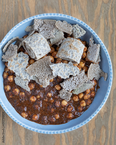 Chickpea with spicy flaxseed sauce meal with pieces of injera flatbread. Ethiopian cuisine homemade dish. photo