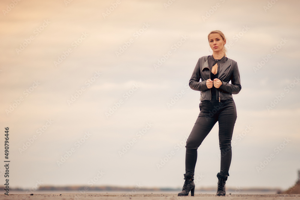 portrait of a blonde woman in a black denim catsuit portrait of a blonde woman in a black denim catsuit