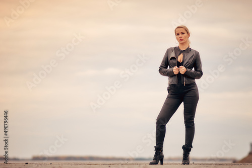 portrait of a blonde woman in a black denim catsuit