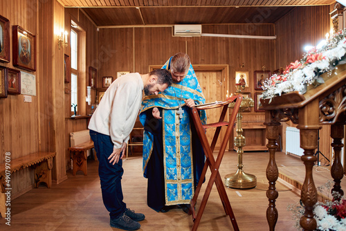 a man repents of his sins, confesses with a priest in the Orthodox church