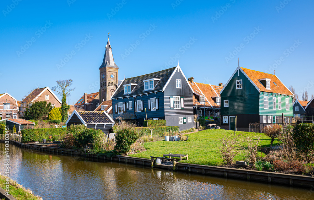 Idyllic scenery with church and traditional wooden houses in the historic village of Marken, Netherlands