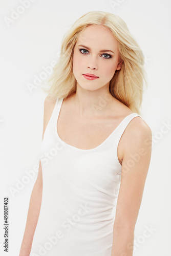 Casual radiance. Portrait of a beautiful blonde against a white background.