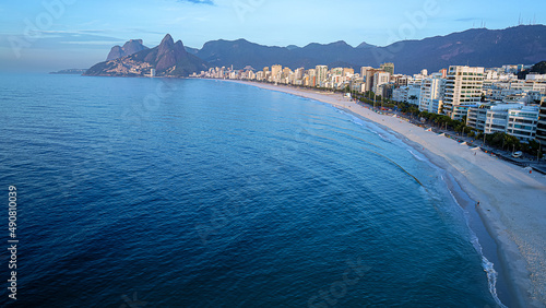 vista aérea da maravilhosa paisagem das praias de Ipanema e do Leblon, com seus prédios entre a majestosa cadeia de montanhas que termina com o morro dois irmãos e o belíssimo mar azul photo