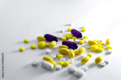 Iluminación dramática de píldoras y aspirinas sobre fondo blanco. photo