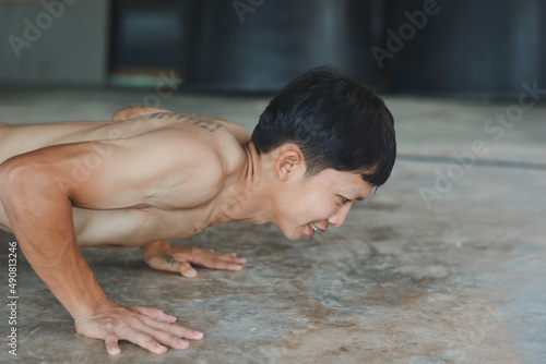 Young Asian men are exercising by doing push-up moves to build healthy and healthy muscles.