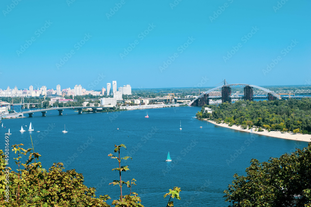 Fototapeta premium Landscapes of Kyiv, river station, pedestrian bridge, monument of The Motherland Calls, beautiful buildings and streets
