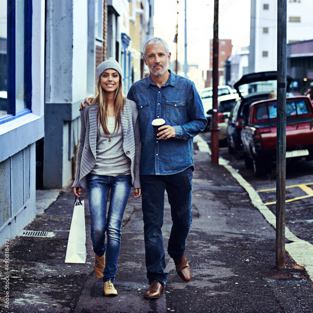 They decided to hit town today. Portrait of a father and daughter walking together in the city with their shopping and takeaway coffee.
