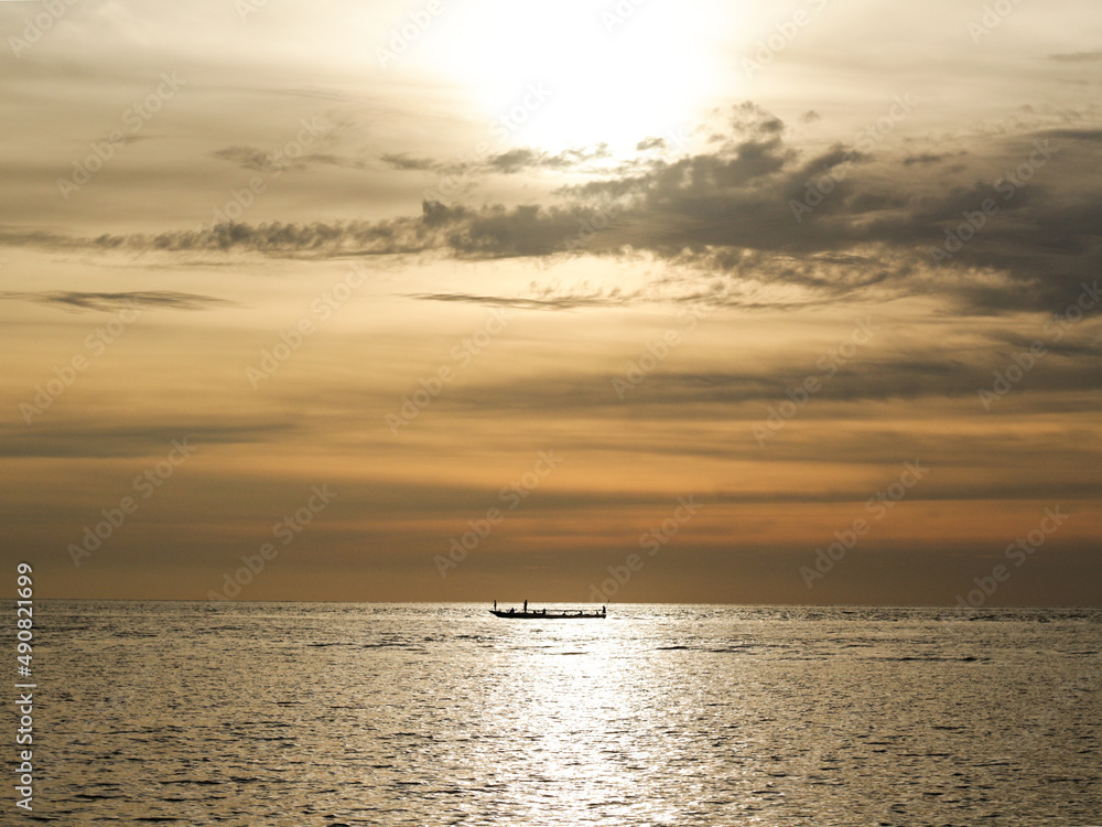 A silhouette of boat with sunset as background
