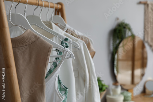 Rack with stylish women's clothes in dressing room, closeup