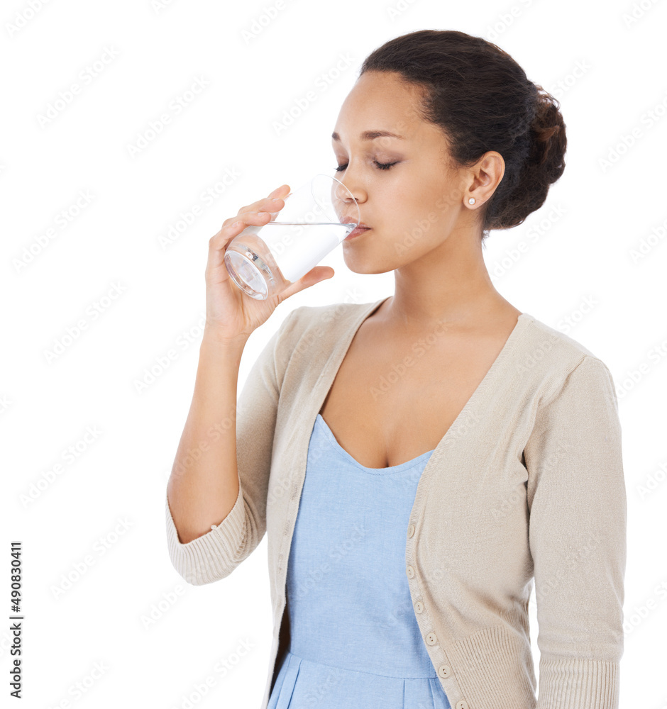 Making sure to drink enough water. Young woman drinking a glass of water - isolated on white. Making sure to drink enough water. Young woman drinking a glass of water - isolated on white.