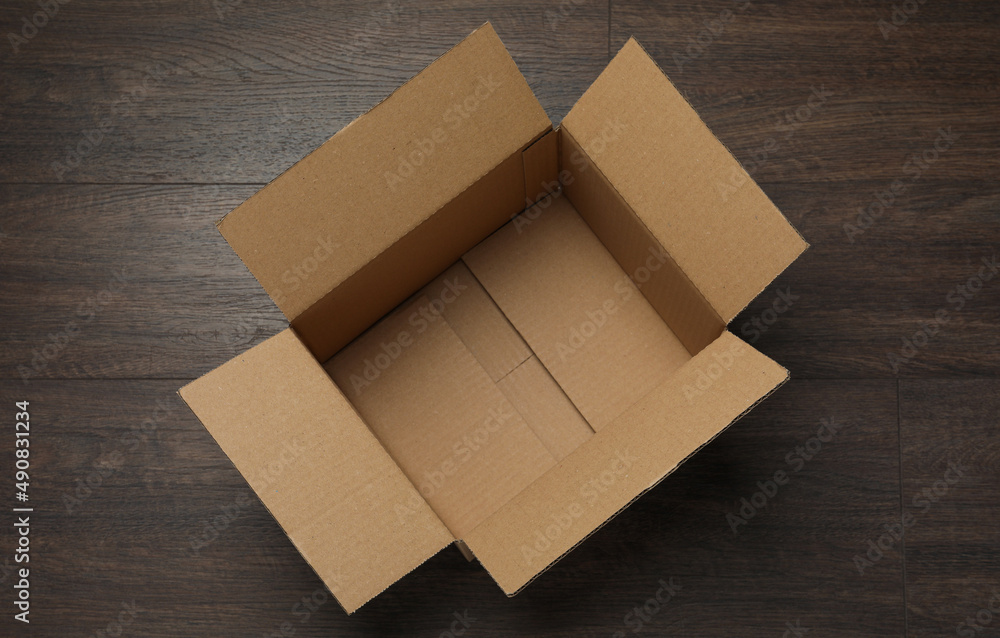 Empty open cardboard box on wooden table, top view Empty open cardboard box on wooden table, top view