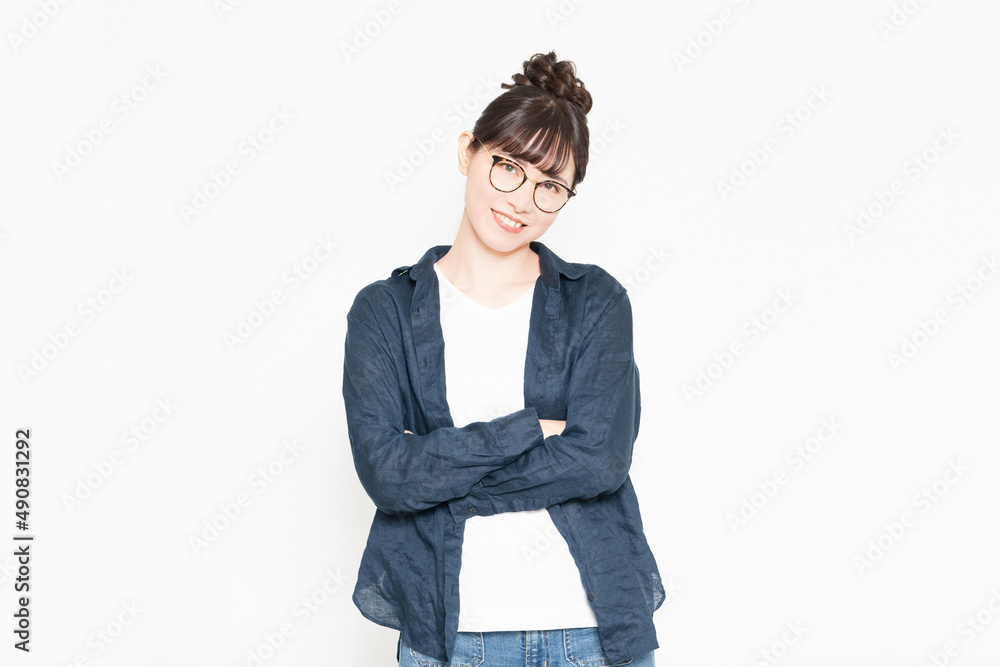 白い背景の前に立って腕組みしている眼鏡をかけている女性 白い背景の前に立って腕組みしている眼鏡をかけている女性